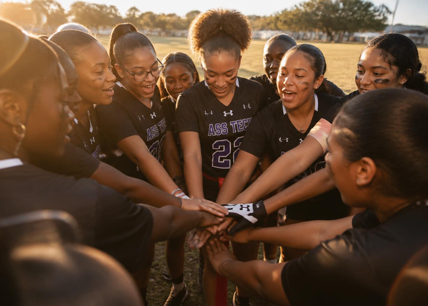 A girls flag football team huddled together before practice